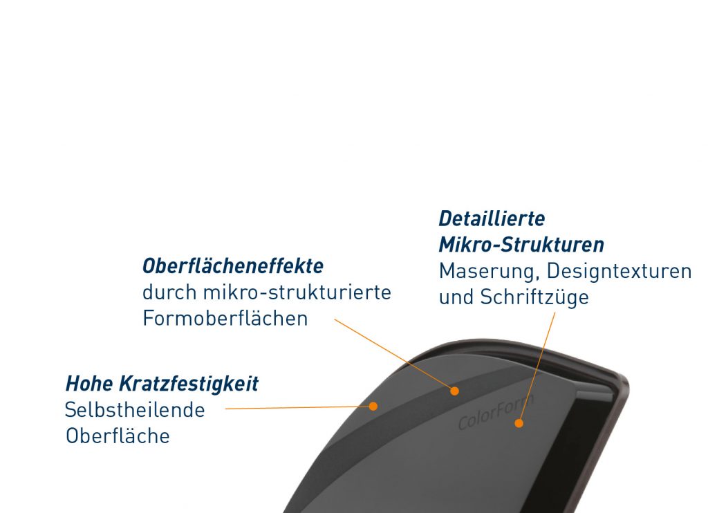 A close-up of a black, curved object labeled ColorF with German text and arrows highlighting features: surface effects from micro-structuring via spritzgießen, high scratch resistance from a self-healing surface, and detailed textures and lettering.